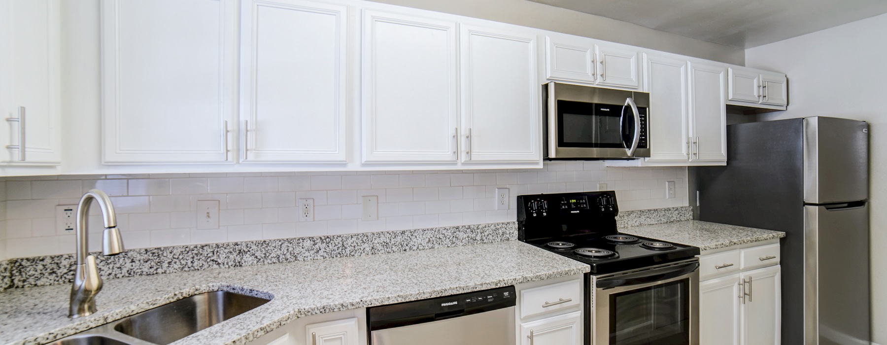 Apartment kitchen with white cabinets