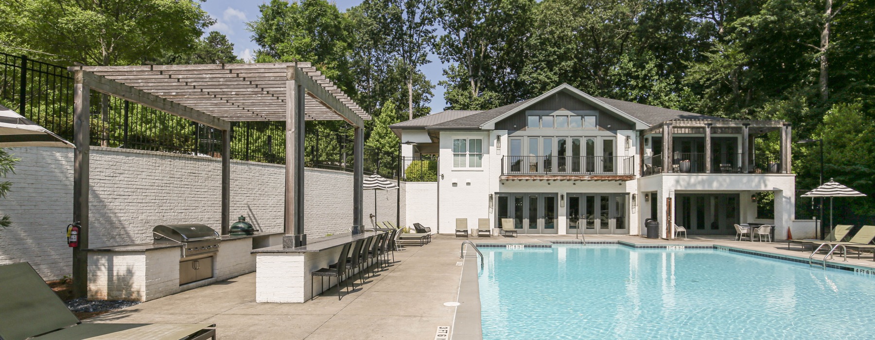 Grilling next to pool with large building in the back