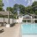 Grilling next to pool with large building in the back