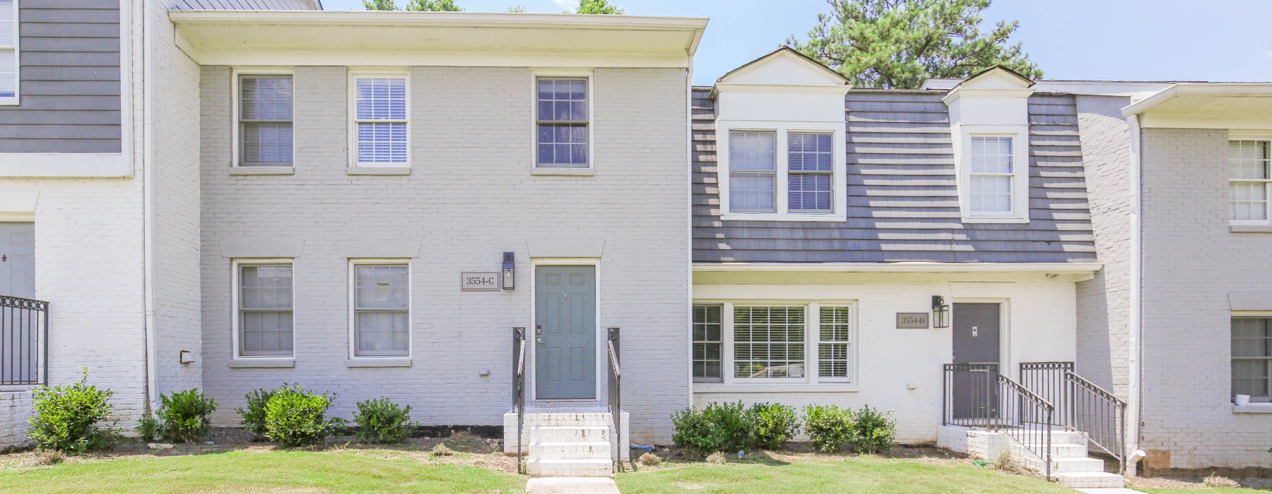 Brick painted townhome exterior with sidewalk